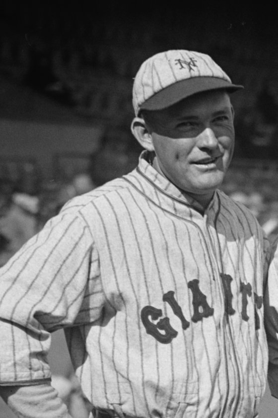 Rogers Hornsby smiling in a New York Giants pinstriped uniform and NY cap on a ballfield, 1927