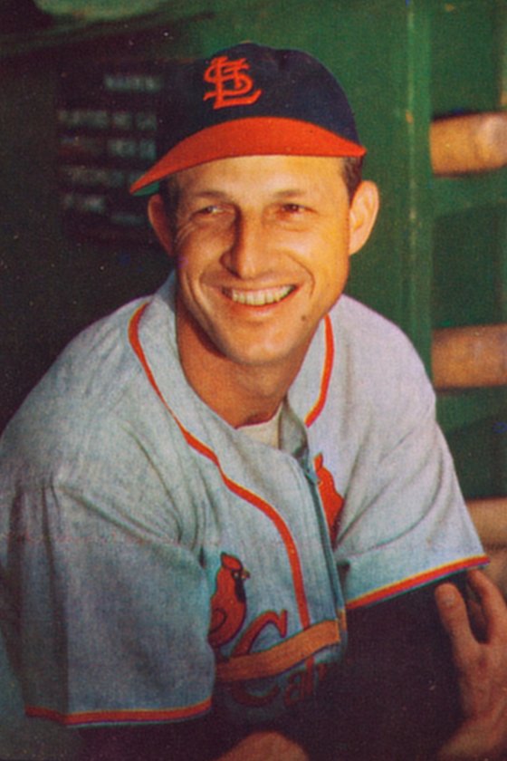 Stan Musial smiling in the dugout in his St. Louis Cardinals cap and birds-on-the-bat jersey, 1953
