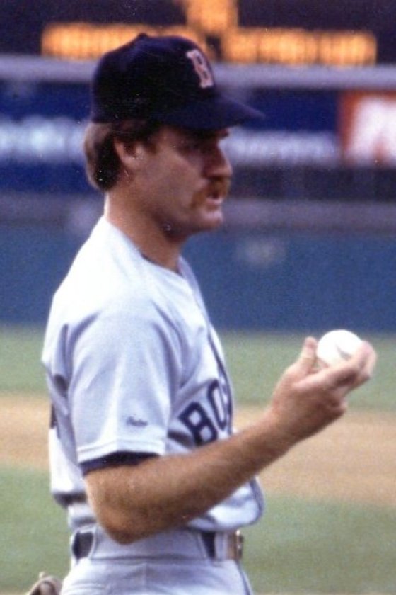 Wade Boggs in a gray Boston Red Sox road uniform and cap, holding a baseball before a game at Baltimore’s Memorial Stadium, 1988